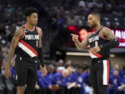 Portland Trail Blazer Damian Lillard (0) explains defensive coverage with teammate Anfernee Simons (1) in the first quarter of an NBA preseason basketball game in Sacramento, Calif., Sunday, Oct. 9, 2022. (AP Photo/Jos?