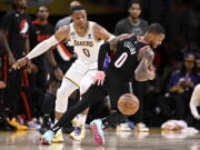 Portland Trail Blazers guard Damian Lillard, right, loses the ball with Los Angeles Lakers guard Russell Westbrook defending during the first half of an NBA basketball game Sunday, Oct. 23, 2022, in Los Angeles.