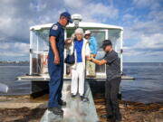 A resident is assisted from a ferry after returning from Pine Island, Fla., after Hurricane Ian, Tuesday, Oct. 4, 2022.