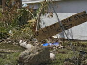 Residents placed a "you loot, we shoot" sign on their their flooded property Tuesday, Oct. 4, 2022, in North Port, Fla. Residents in the area continue cleaning up after Hurricane Ian came ashore along Florida's west coast last week.