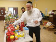 Rabbi Yitzchok Minkowicz supervises the pantry inside the Chabad Lubavitch of Southwest Florida, Monday, Oct. 3, 2022, in Fort Myers, Fla. The synagogue has been transformed into a full-fledged community center with food trucks and a pantry. They plan on celebrating Yom Kippur on Tuesday.