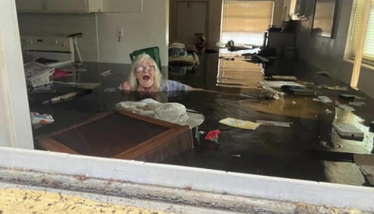 Johnny Lauder's mother, Karen Lauder, 86, is submerged nearly to her shoulders in water that has flooded her home, in Naples, Fla., on Sept. 28, following Hurricane Ian.