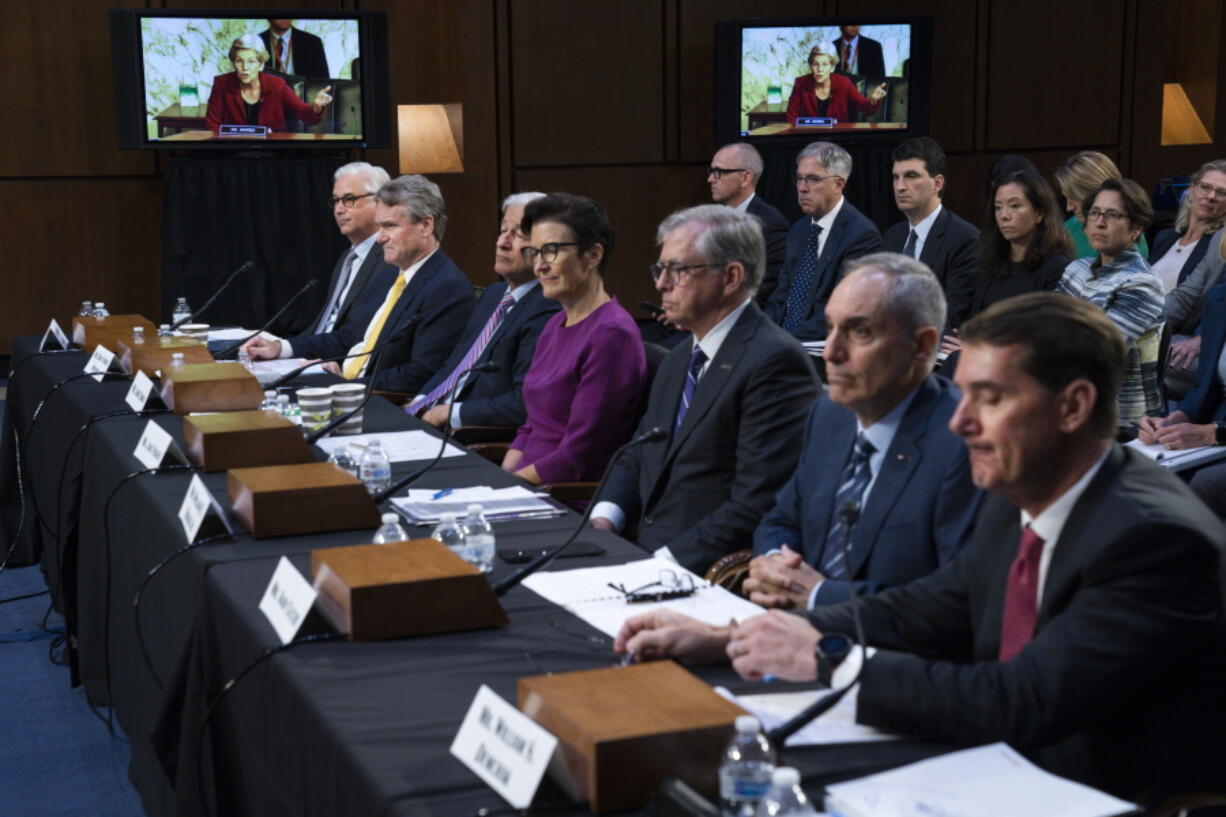 FILE - Sen. Elizabeth Warren, D-Mass., on a screen in the background, questions witnesses about Zelle, during a Senate Banking Committee annual Wall Street oversight hearing, Sept. 22, 2022, on Capitol Hill in Washington. On the panel from left, Wells Fargo & Company CEO and President Charles Scharf, Bank of America Chairman and CEO Brian Thomas Moynihan, JPMorgan Chase & Company Chairman and CEO Jamie Dimon, Citigroup CEO Jane Fraser, Truist Financial Corporation Chairman and CEO William Rogers Jr., U.S. Bancorp Chairman, President, and CEO Andy Cecere, and The PNC Financial Services Group Chairman, President, and CEO William Demchak.