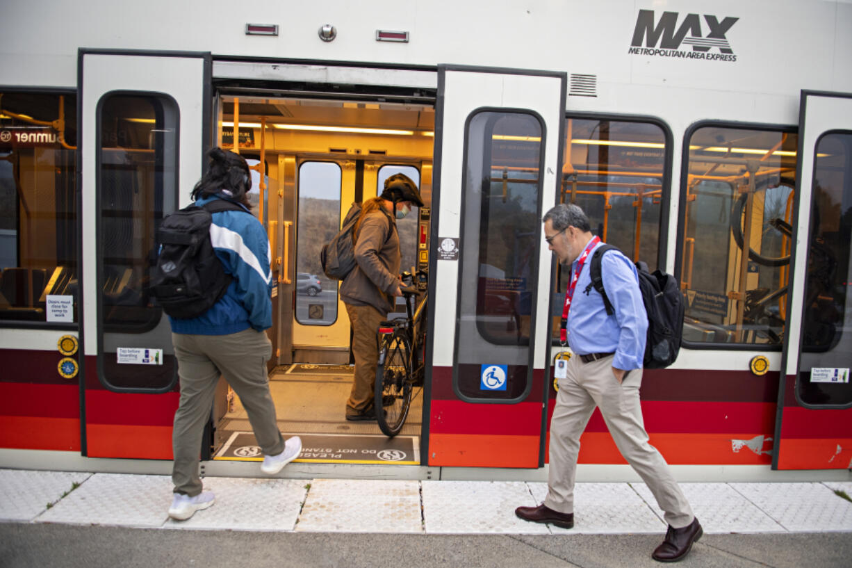 Joseph Fowler, right, is one of roughly 65,000 Clark County workers who commute to Portland. But unlike most of them, he rides public transportation.  At top, a C-Tran bus stops at the Fisher's Landing Transit Center before taking commuters to the Parkrose/Sumner transit center in Portland so they can board a MAX light rail train.