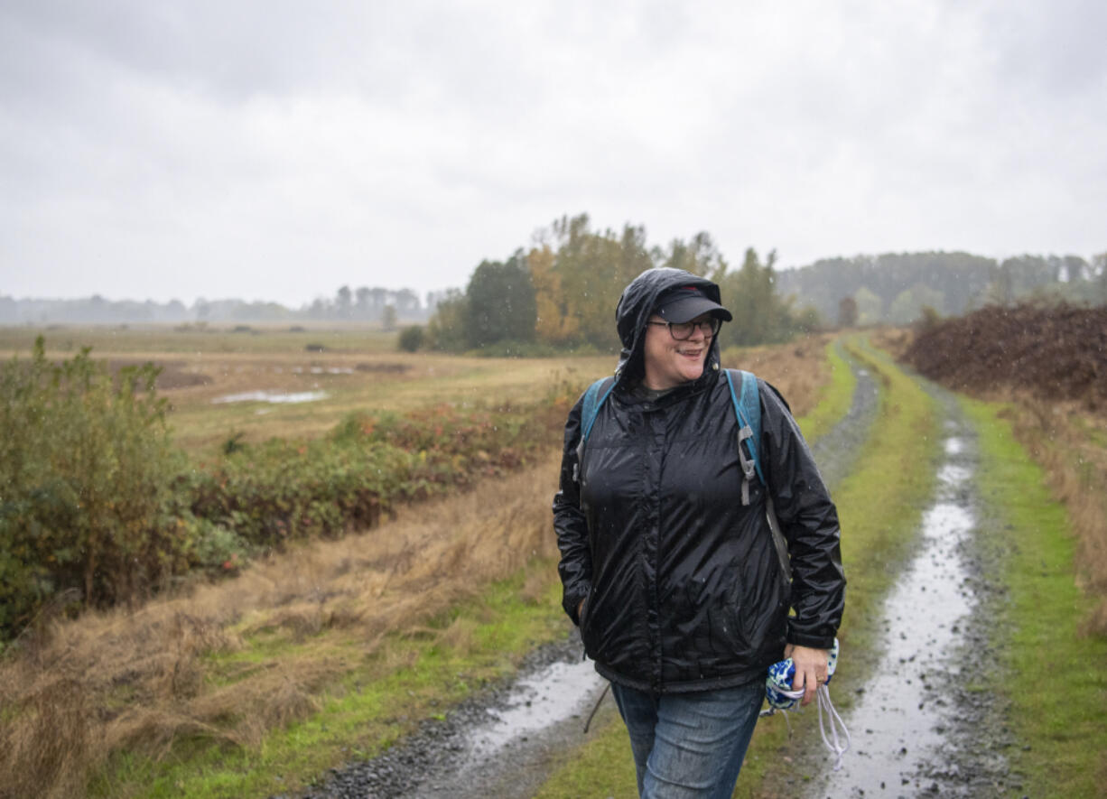 Eileen Cowen of Vancouver walks down a road at Shillapoo Wildlife Area to forage for berries, mushrooms and other goods.