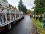 Vancouver Fire Truck No. 1 displays photos of local veterans killed in action on Saturday during the Lough Legacy Veterans Parade along Evergreen Boulevard in Vancouver. At top, the Oregon Volunteer Infantry marches in the parade.