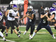 Skyview junior Trey Jacob, center, dashes through an opening Friday, Nov. 4, 2022, during the Storm’s 14-11 win against Puyallup in a 4A playoff game at Kiggins Bowl.