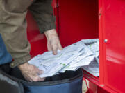 Clark County elections worker Greg Talbert loads ballots into a ballot bag Nov. 8, 2022, at Fisher's Landing Transit Center.