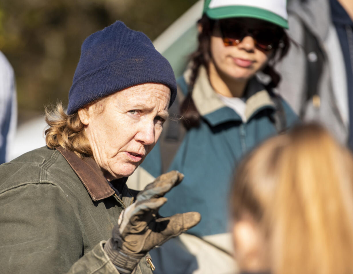 Sandy Haigh of the Center for Ecodynamic Restoration directs a group of Clark College students planting wildflowers to restore pollinator habitat at Sams Walker Day Use Area near Skamania last week.