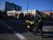 Pablo Rodriguez, who escaped Cuba as a child with his family and is now experiencing homelessness in Vancouver, crosses the street while helping to clean litter, graffiti, signs and stickers downtown on a Monday afternoon. Rodriguez currently works part time at Vancouver's Downtown Association keeping the downtown area in top condition.