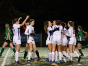 Columbia River players swarm goalscorer Avah Eslinger after a second-half brace in the 2A state soccer semifinals on Friday at Shoreline Stadium.