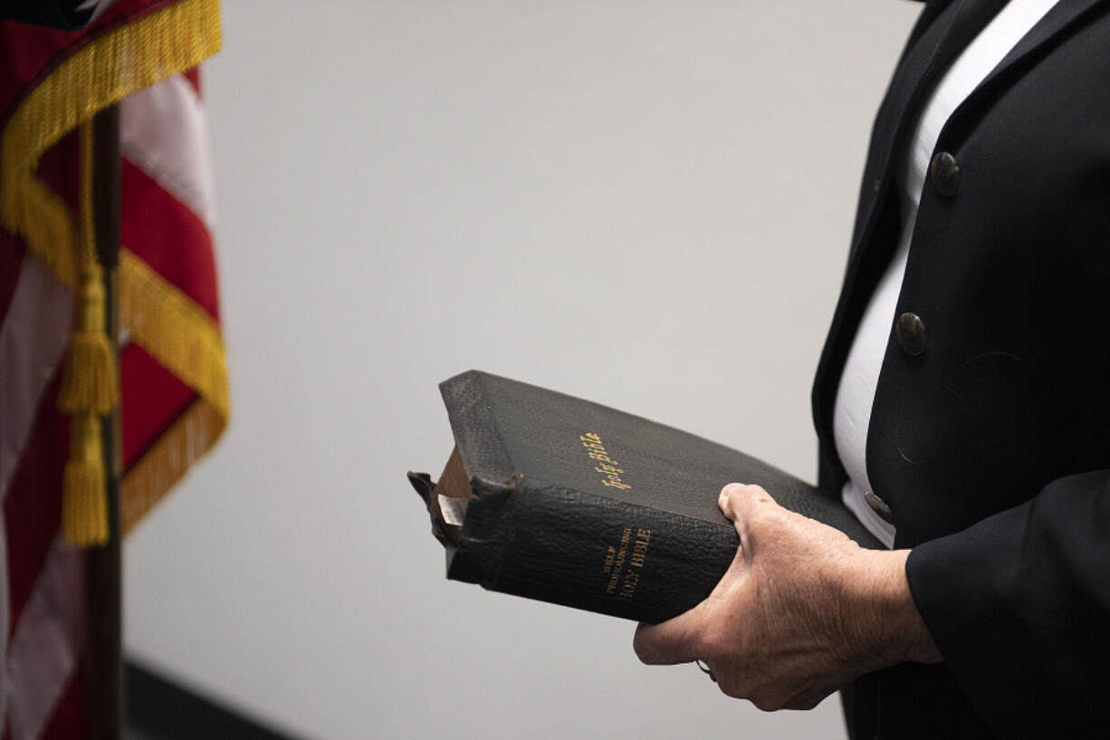 Sue Marshall, new District 5 Clark County Councilor, holds a copy of the Bible as she is sworn in at the Clark County Elections Office Wednesday afternoon.