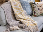 Two layered throw blankets make for a snuggly and inviting couch display.