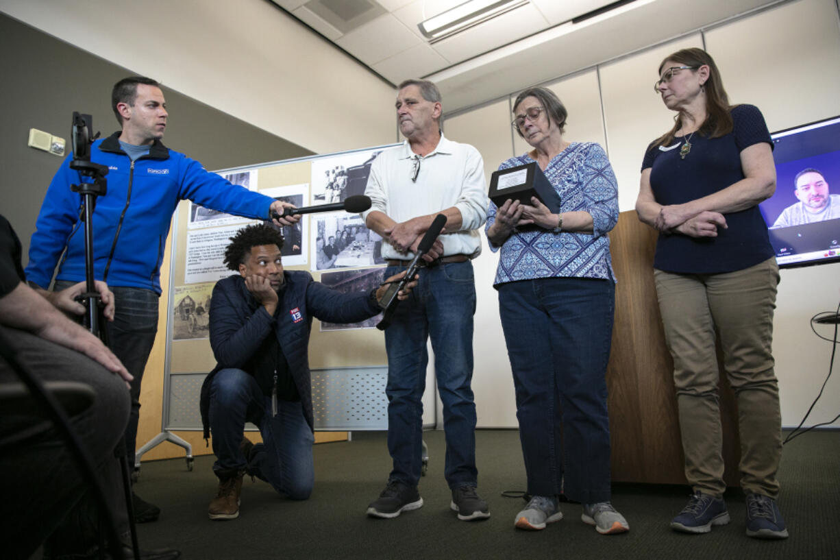 Douglas and Diane Ames stand on each side of their mother, Margaret Ames, as Margaret fields questions from the media while holding the remains of her father-in-law Othaniel Philip Ames during a press conference identifying Otie as the previously unidentified ???I-5- Stilly Doe??? on Thursday, Nov. 10, 2022, at the Snohomish County Administration Building East in Everett, Washington.