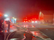 Firefighters decontaminate after extinguishing a fire Tuesday morning at an Orchards business complex. The Vancouver Fire Department upgraded the response to a second alarm and received assistance from Clark County Fire District 6 and Clark County Fire District 3.