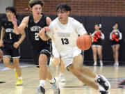 Union's Yanni Fassilis, right, dribbles up the floor while being closely guarded by North Kitsap's Mason Chmielewski in the Titans' season opener on Saturday, Nov. 26, 2022, at Union High School.