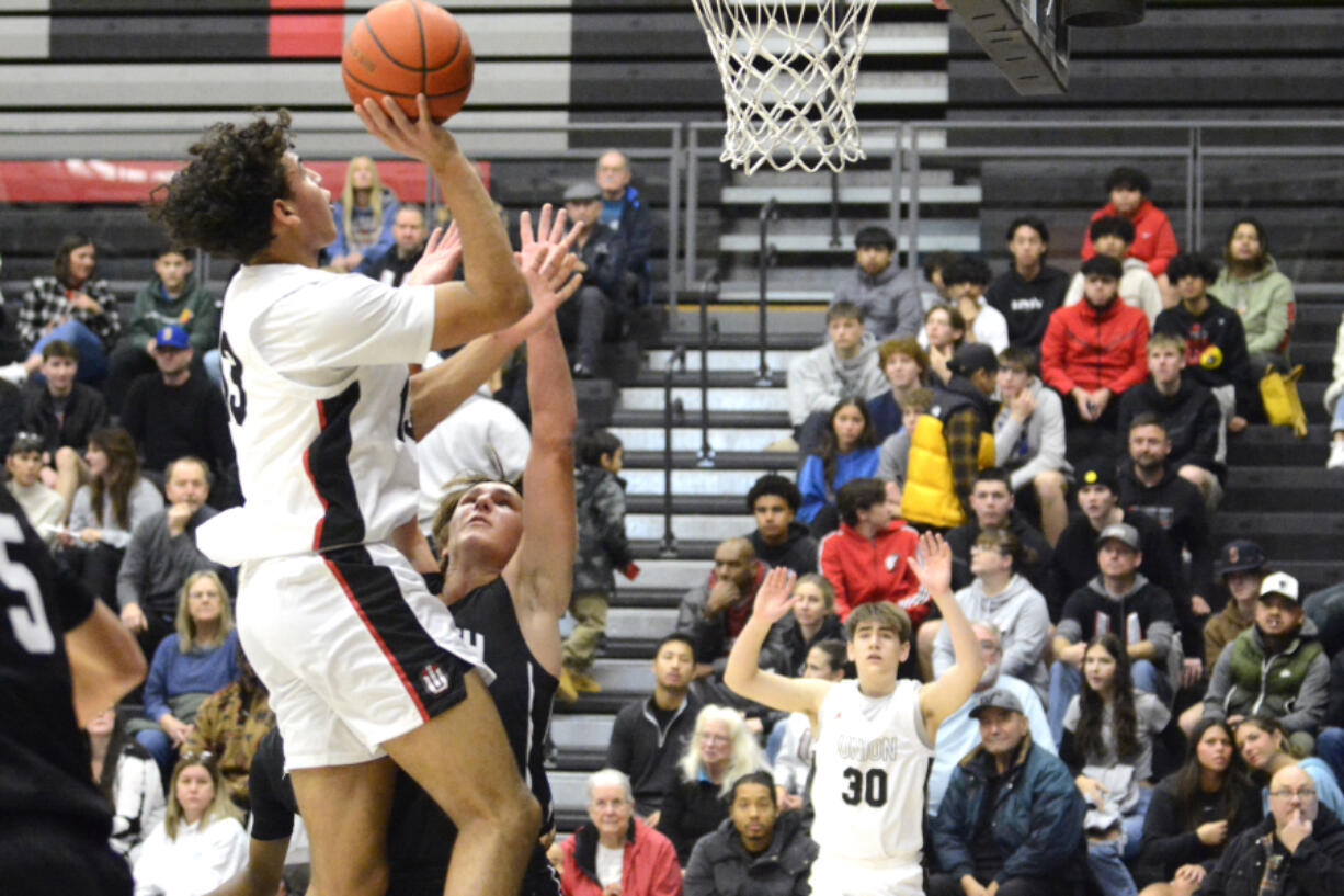 Union's Yanni Fassilis, left, elevates over North Kitsap's Mason Chmielewski for a basket in the Titans' season opener on Saturday, Nov. 26, 2022, at Union High School.