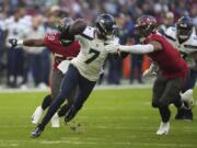 Seattle Seahawks quarterback Geno Smith (7) is sacked by Tampa Bay Buccaneers' Joe Tryon-Shoyinka (9) during the first half of an NFL football game, Sunday, Nov. 13, 2022, in Munich, Germany.