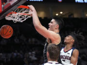 Purdue center Zach Edey dunks against Gonzaga guard Hunter Sallis, right, during the first half of an NCAA college basketball game in the Phil Knight Legacy tournament Friday, Nov. 25, 2022, in Portland, Ore.