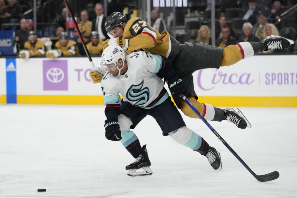 Vegas Golden Knights defenseman Shea Theodore, right, collides with Seattle Kraken right wing Jordan Eberle (7) during the third period of an NHL hockey game Friday, Nov. 25, 2022, in Las Vegas.