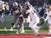 Washington State running back Nakia Watson, center left, runs in for a touchdown while defended by Arizona State linebacker Will Shaffer (28) during the first half of an NCAA college football game, Saturday, Nov. 12, 2022, in Pullman, Wash.