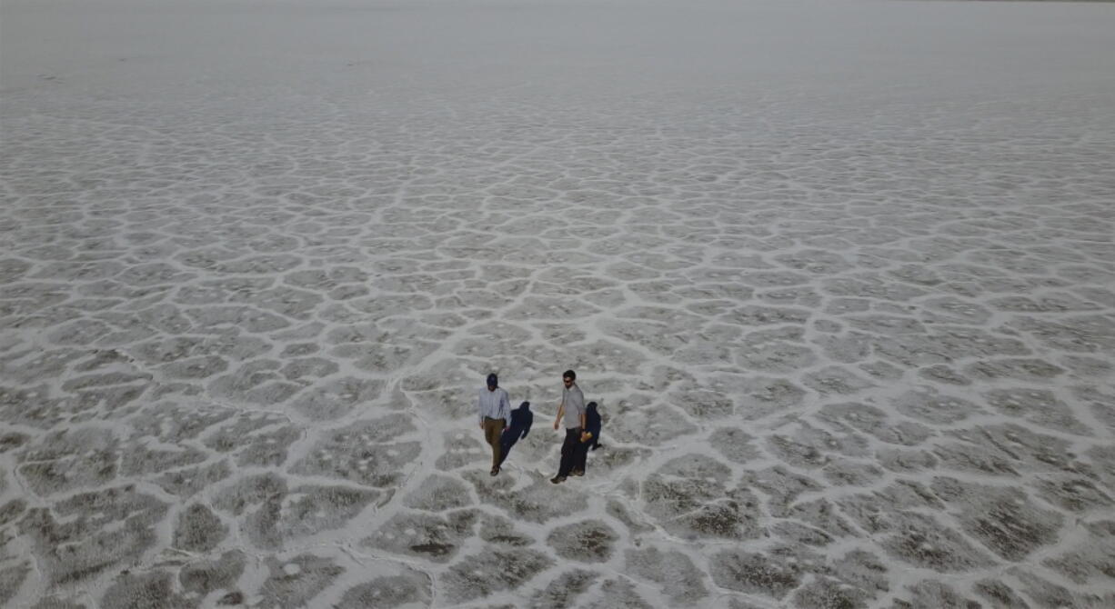 State of Utah Department of Natural Resources geologists Paul Inkenbrandt, left, and Jeremiah Bernau walk along the Bonneville Salt Flats on Aug. 29, 2022, near Wendover, Utah. The glistening white salt of the world famous area is shrinking near the Utah-Nevada line.