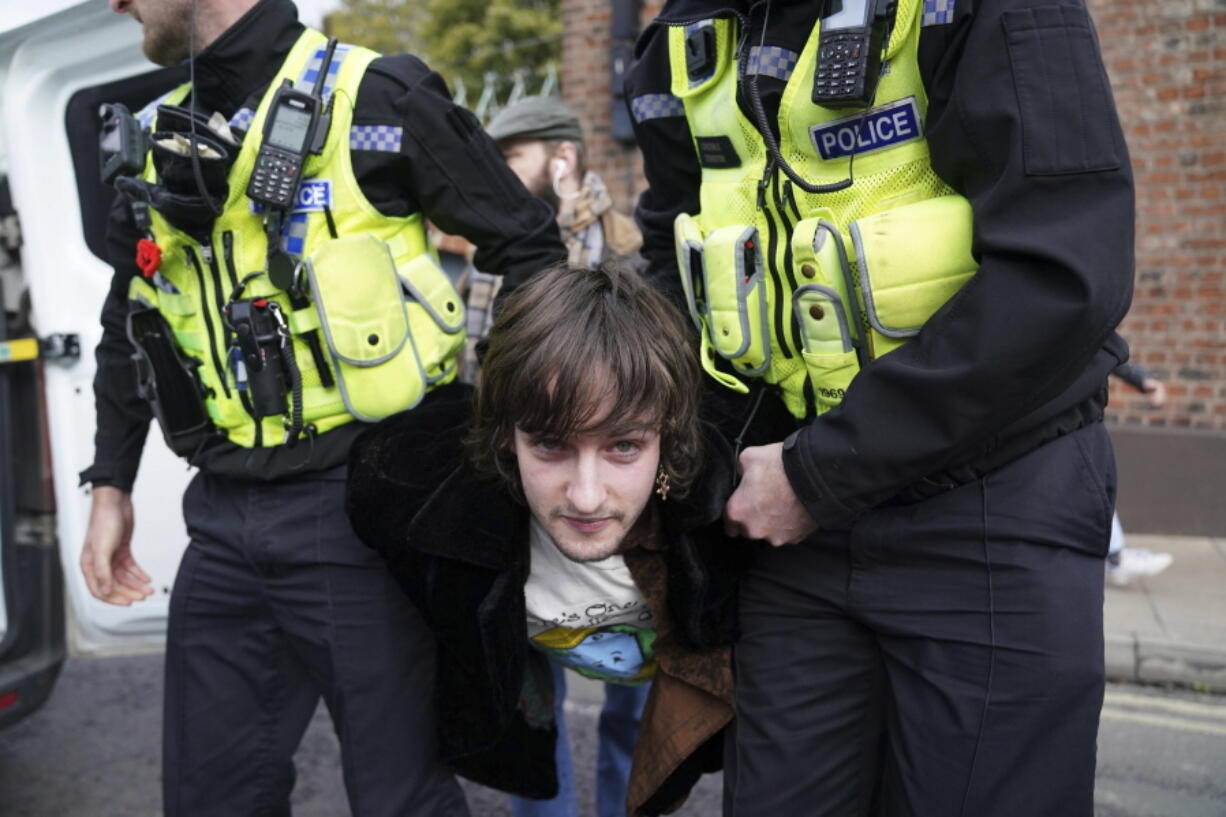 Police detain a protester after he appeared to throw eggs at Britain's King Charles III and the Queen Consort as they arrived for a ceremony at Micklegate Bar, where the Sovereign is traditionally welcomed to the city, in York, England, Wednesday Nov. 9, 2022.