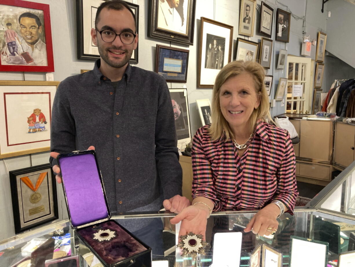 Zachary Diaz, left, and Elizabeth Haynie Wainstein, of The Potomack Compan,y display items from the estate of Gen. Colin Powell on Thursday, Nov. 3, 2022, in Alexandria, Va. A collection from the estate of the general of nearly 400 items stretching from the momentous to mundane is currently up for auction.