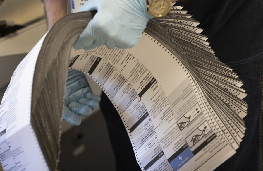 Ballots are prepared to be sent through a scanner on Election Day at the King County Elections headquarters, Tuesday, Nov. 8, 2022, in Renton, Wash.