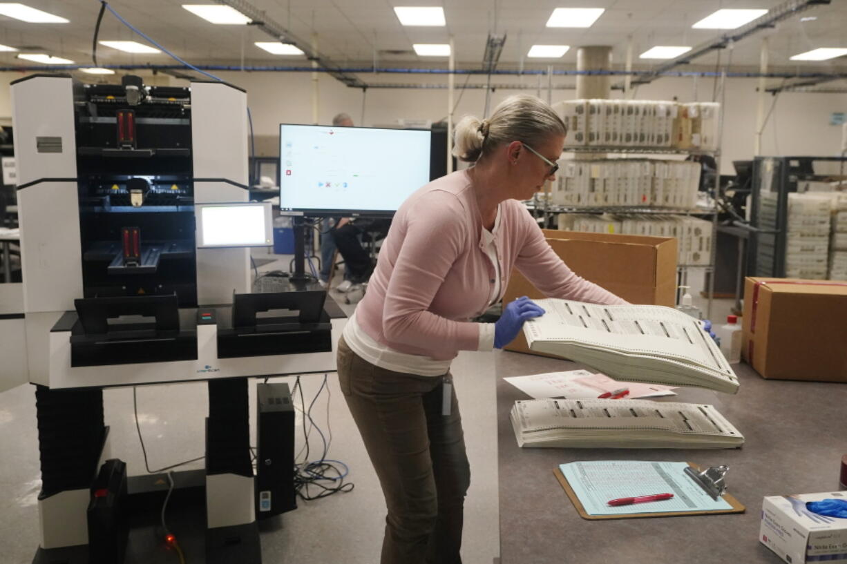 An election worker holds a stack of counted ballots at the Maricopa County Recorders Office in Phoenix, Thursday, Nov. 10, 2022. (AP Photo/Ross D.