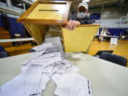 FILE - Steve Diorio, the Chair of the Hinsdale, N.H., Select Board, dumps out nearly 1900 ballots onto a table to be hand-counted at the Hinsdale Middle High School on Nov. 3, 2020 in Hinsdale, N.H. Election experts oppose hand-counting ballots because it takes longer than counting with machines, it's less reliable and it's a logistical nightmare for U.S. elections.