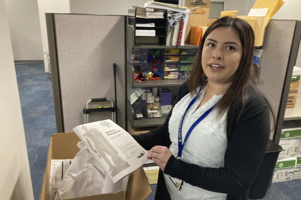 Alma Whalen, who oversees election law investigations, campaign finance disclosures and compliance for Oregon's elections division, holds a voter guide during an interview Oct. 17 in Salem, Ore.