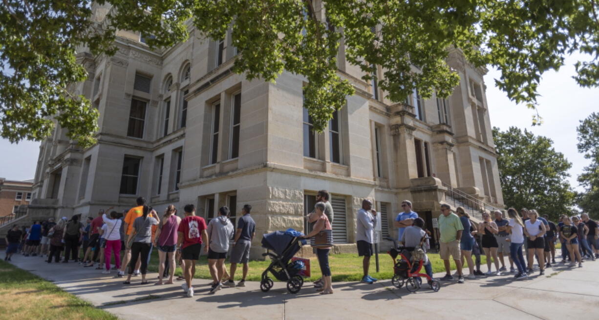 FILE - A long line of voters wraps around the Sedgwick County Historic Courthouse in Wichita, Kan., on the last day of early voting on Aug. 1, 2022. Kansas' top elections official warned voters Monday, Oct. 31, 2022, that text messages they were receiving could give them incorrect information about where to vote, but two national groups involved in the texting said they were not trying to confuse or mislead people.