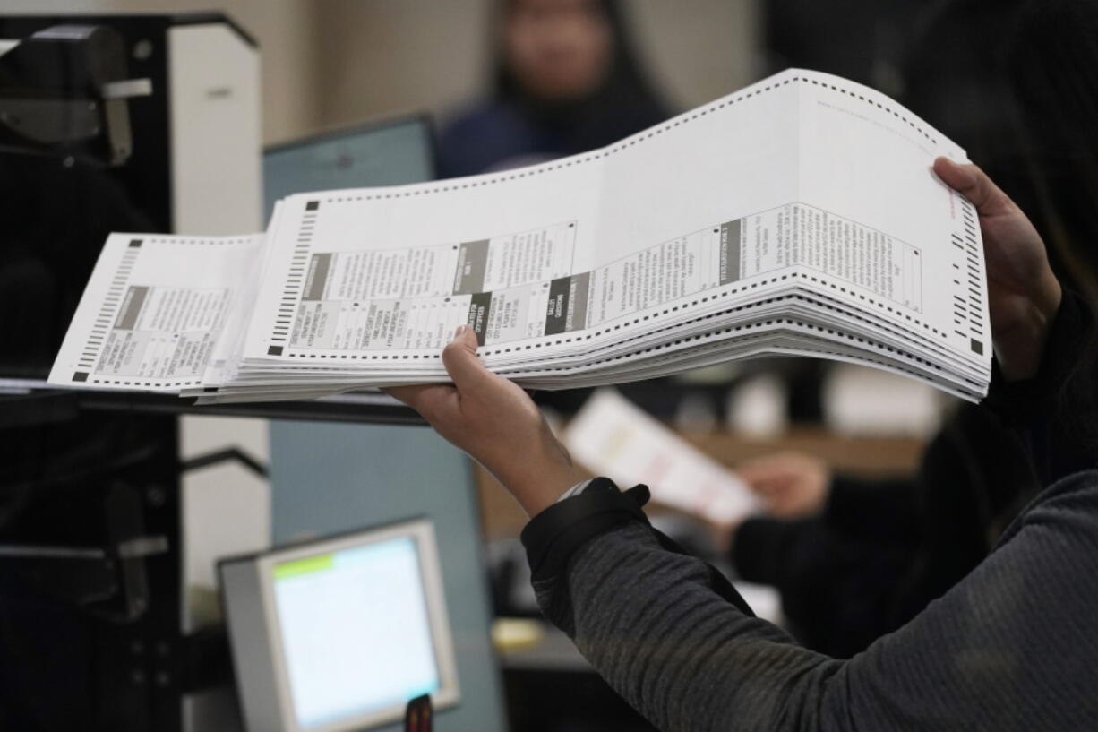 An election worker processes ballots at the Clark County Election Department, Friday, Nov. 11, 2022, in Las Vegas.