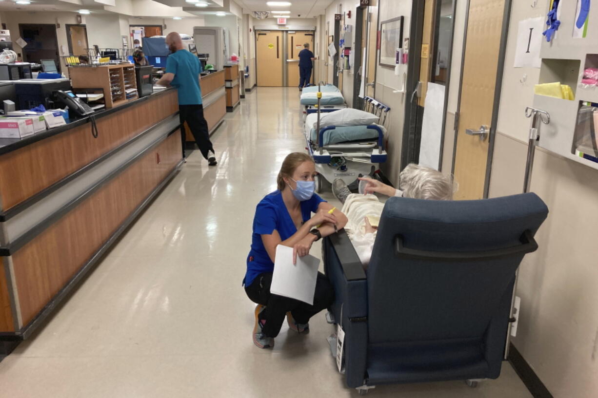 FILE - A nurse talks to a patient in the emergency room at Salem Hospital in Salem, Ore., on Aug. 20, 2021. Oregonians will vote Tuesday, Nov. 8, 2022, on a slate of measures including one that would add a permit and in-person firearms training class for new gun buyers and another that would make Oregon the first state to mandate health care as a human right.