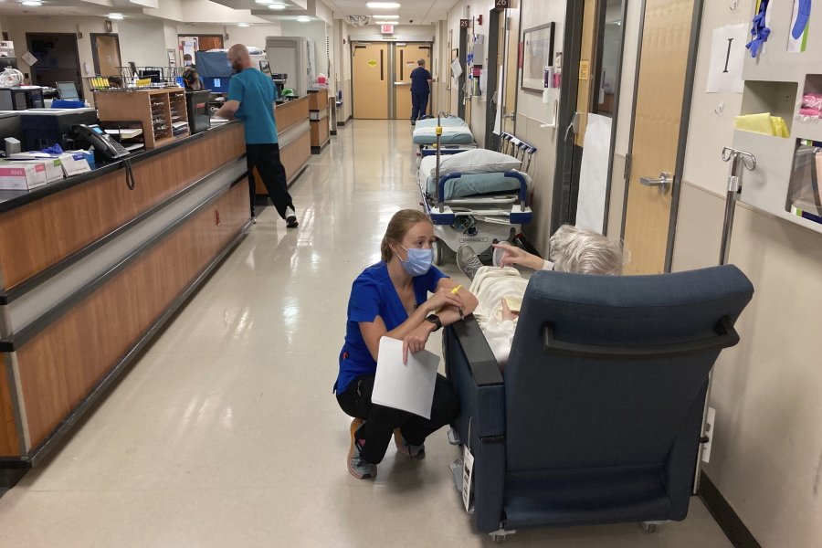 FILE - A nurse talks to a patient in the emergency room at Salem Hospital in Salem, Ore., on Aug. 20, 2021. Oregonians will vote Tuesday, Nov. 8, 2022, on a slate of measures including one that would add a permit and in-person firearms training class for new gun buyers and another that would make Oregon the first state to mandate health care as a human right.