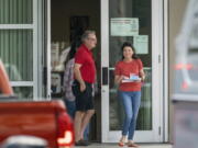 FILE - Voters exit the polls after casting their ballots on the first day of early voting at the Supervisor of Elections Main Office in West Palm Beach, Fla., on Oct. 24, 2022. Election officials in some Florida counties urged people to vote early Sunday, Nov. 6, where possible as a potential tropical system threatens the state on Election Day. The Palm Beach County elections supervisor, Wendy Sartory Link, said voters who want to avoid weather-related disruptions should cast their ballots by 7 p.m. Sunday.