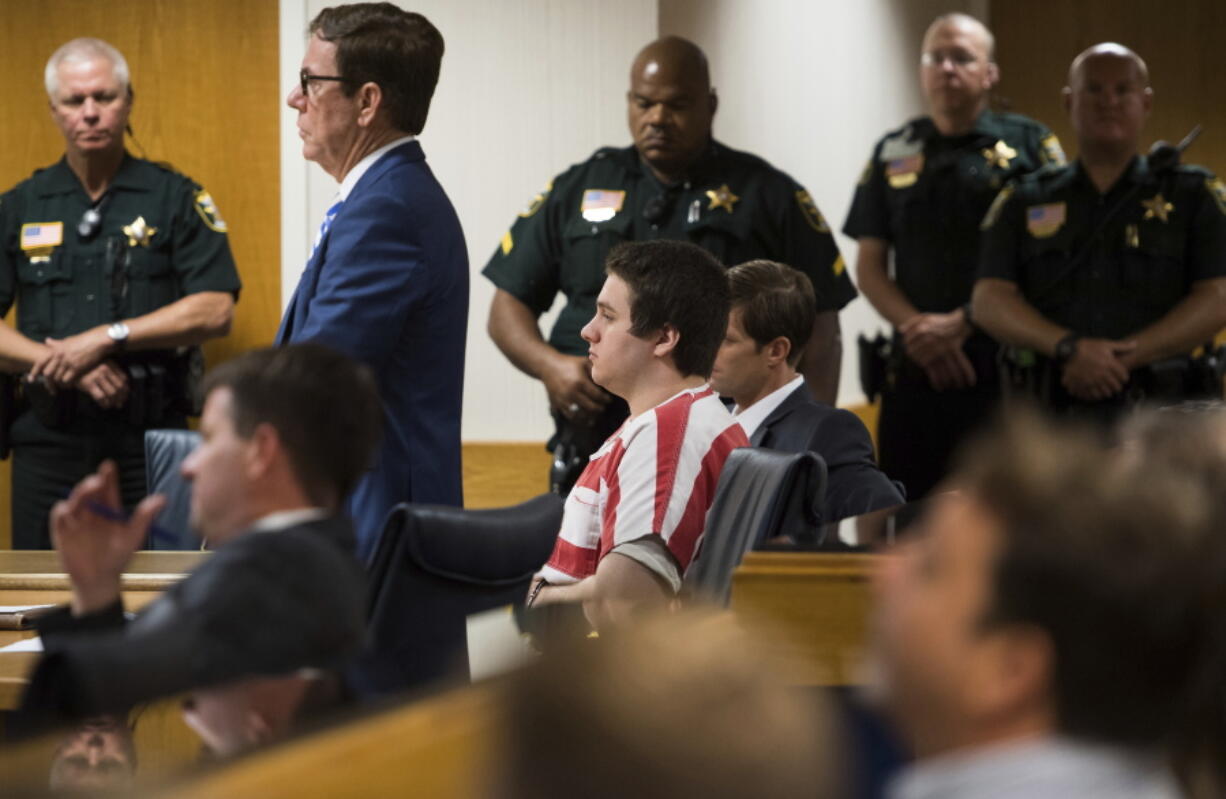 FILE - Austin Harrouff, center, wearing stripes, accused of brutally killing a Tequesta couple in 2016, appears Friday, Aug. 2, 2019, at the Martin County Courthouse in Stuart, Fla., as defense attorney Robert Watson, standing in front of Harrouff, asks Martin County Circuit Judge Sherwood Bauer Jr., to not allow video recording of a mental health evaluation to be conducted by a psychologist hired by the state. Harrouff, a former college student who killed a Florida couple in their garage six years earlier and then chewed on one victim's face, is finally set to go on trial, Monday, Nov. 21, 2022.