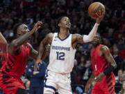 Memphis Grizzlies guard Ja Morant shoots in front of Portland Trail Blazers forward Nassir Little, left, during the second half of an NBA basketball game in Portland, Ore., Wednesday, Nov. 2, 2022.