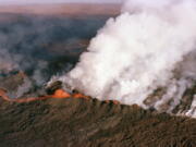 FILE - A gaseous cloud rises from the crater of Mauna Loa, center, on the big island of Hawaii, April 4, 1984. The ground is shaking and swelling at Mauna Loa, the largest active volcano in the world, indicating that it could erupt. Scientists say they don't expect that to happen right away but officials on the Big Island of Hawaii are telling residents to be prepared in case it does erupt soon.