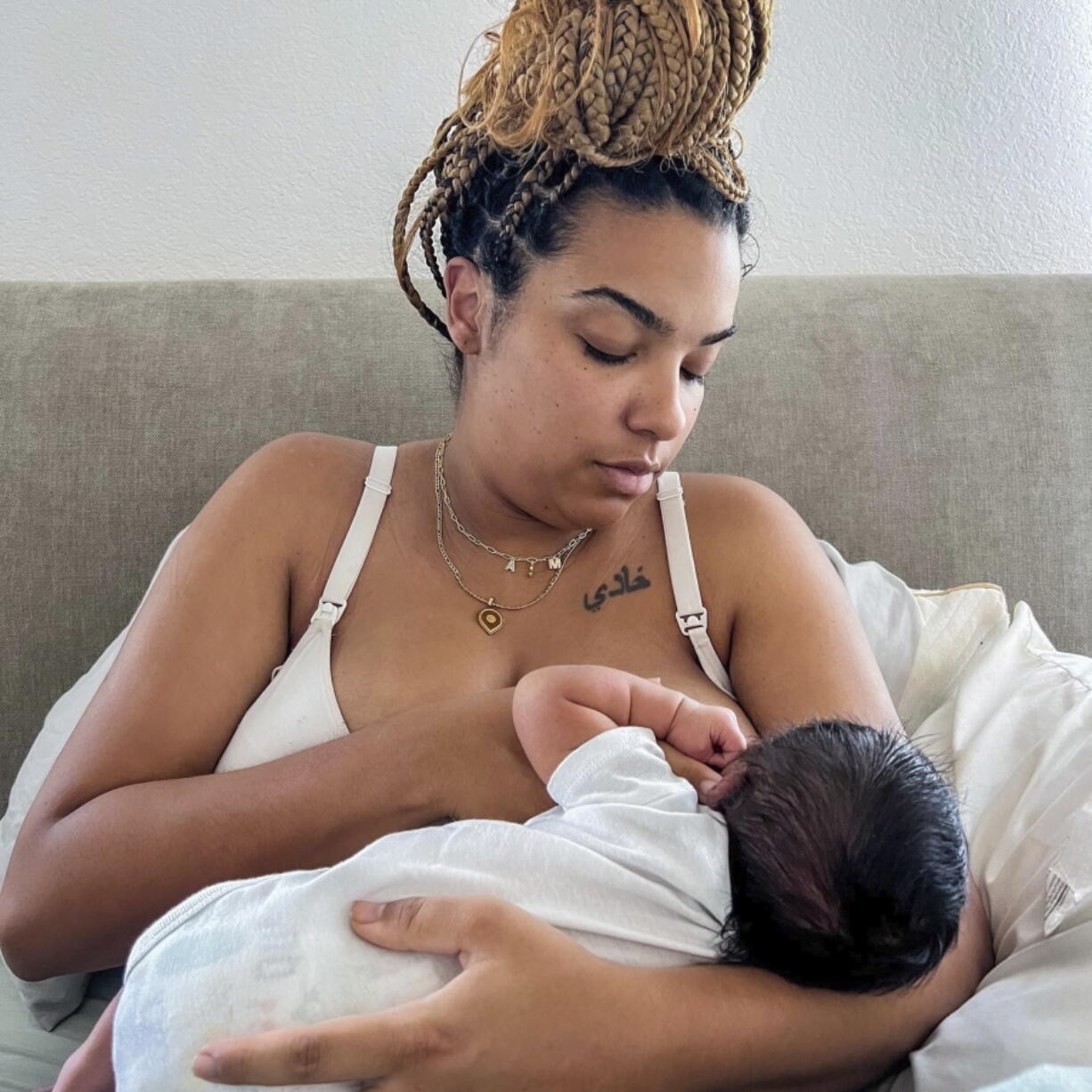 In this photo provided by Mark Godbolt Jr., his wife, Jade Godbolt, nurses her newborn child at their Dallas-area home in October 2022. She and her husband chose a home birth for their third child. Godbolt, 31, says there were no complications and she and her son are doing well. "I believed that my body could do what it was made to do and I wanted to be in the comfort of my home to do that,'' she said. (Mark Godbolt Jr.