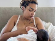 In this photo provided by Mark Godbolt Jr., his wife, Jade Godbolt, nurses her newborn child at their Dallas-area home in October 2022. She and her husband chose a home birth for their third child. Godbolt, 31, says there were no complications and she and her son are doing well. "I believed that my body could do what it was made to do and I wanted to be in the comfort of my home to do that,'' she said. (Mark Godbolt Jr.