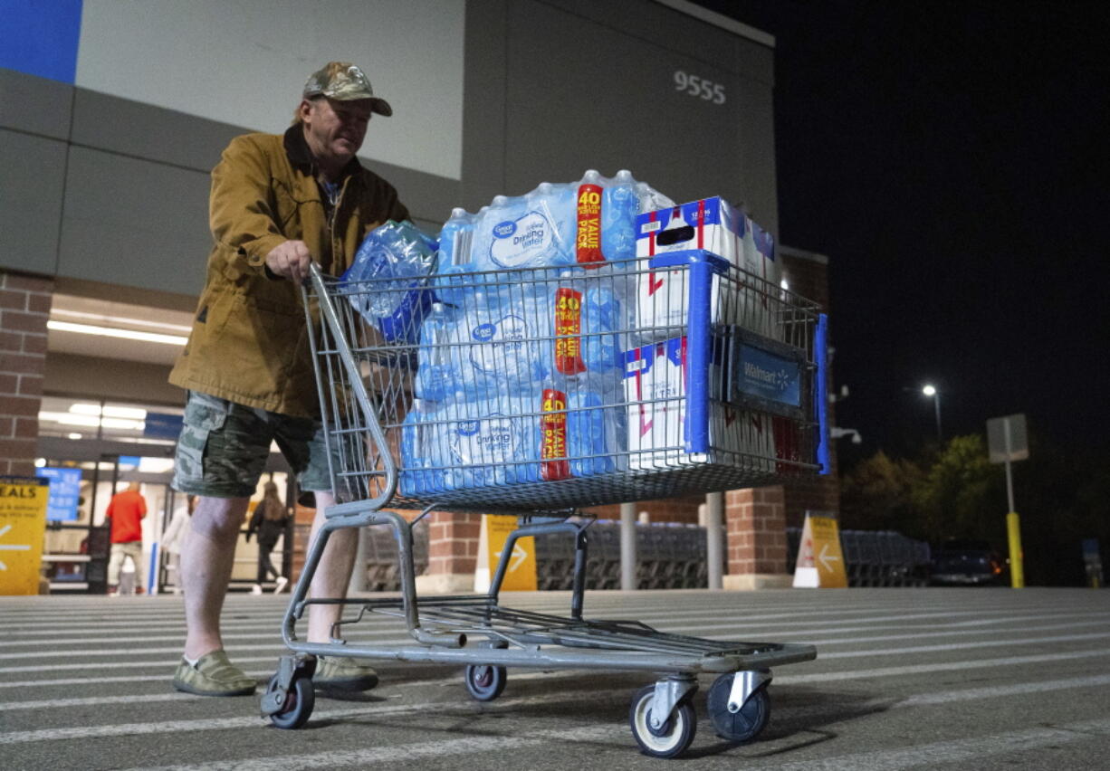 John Beezley, of Bonham, carts out several cases of water after learning that a boil water notice was issued for the entire city of Houston on Sunday, Nov. 27, 2022, at Walmart on S. Post Oak Road in Houston. Beezley just arrived in town with his wife, who is undergoing treatment starting tomorrow at M.D. Anderson Cancer Center, where they are staying in a camping trailer. They turned on the television after settling in and saw that a boil water notice had been issued. Beezley decided to go out immediately fearing that by tomorrow people would be buying up all of the available water.