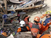 Rescuers search for victims under the rubble of a building collapsed during Monday's earthquake in Cianjur, West Java, Indonesia, Wednesday, Nov. 23, 2022. More rescuers and volunteers were deployed Wednesday in devastated areas on Indonesia's main island of Java to search for the dead and missing from an earthquake that killed hundreds of people.