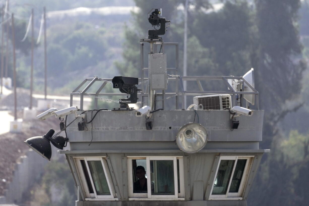 Two robotic guns sit atop a guard tower bristling with surveillance cameras pointed at the Aroub refugee camp in the West Bank, Thursday, Oct. 6, 2022. Israel has installed robotic weapons that can fire tear gas, stun grenades and sponge-tipped bullets at Palestinian protesters. The robots, perched over a crowded Palestinian refugee camp and in a flash point West Bank city, use artificial intelligence to track targets.