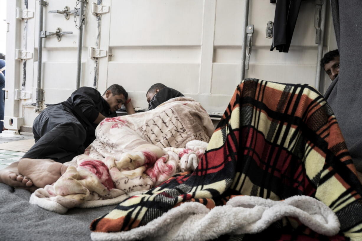 Some of the migrants rescued from the sea are seen on board of the humanitarian ship Ocean Viking cruising in the Mediterranean Sea, Wednesday, Nov. 9, 2022. The SOS Mediterranee humanitarian group said the Norwegian-flagged ship is heading toward the French island of Corsica in hopes that France will offer its 234 passengers a safe port, after Italy backed down and allowed migrants from three other rescue ships to disembark on Italian soil.