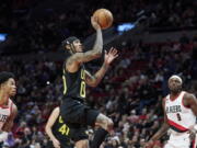 Utah Jazz guard Jordan Clarkson, center, shoots between Portland Trail Blazers guard Anfernee Simons, left, and forward Jerami Grant during the second half of an NBA basketball game in Portland, Ore., Saturday, Nov. 19, 2022.