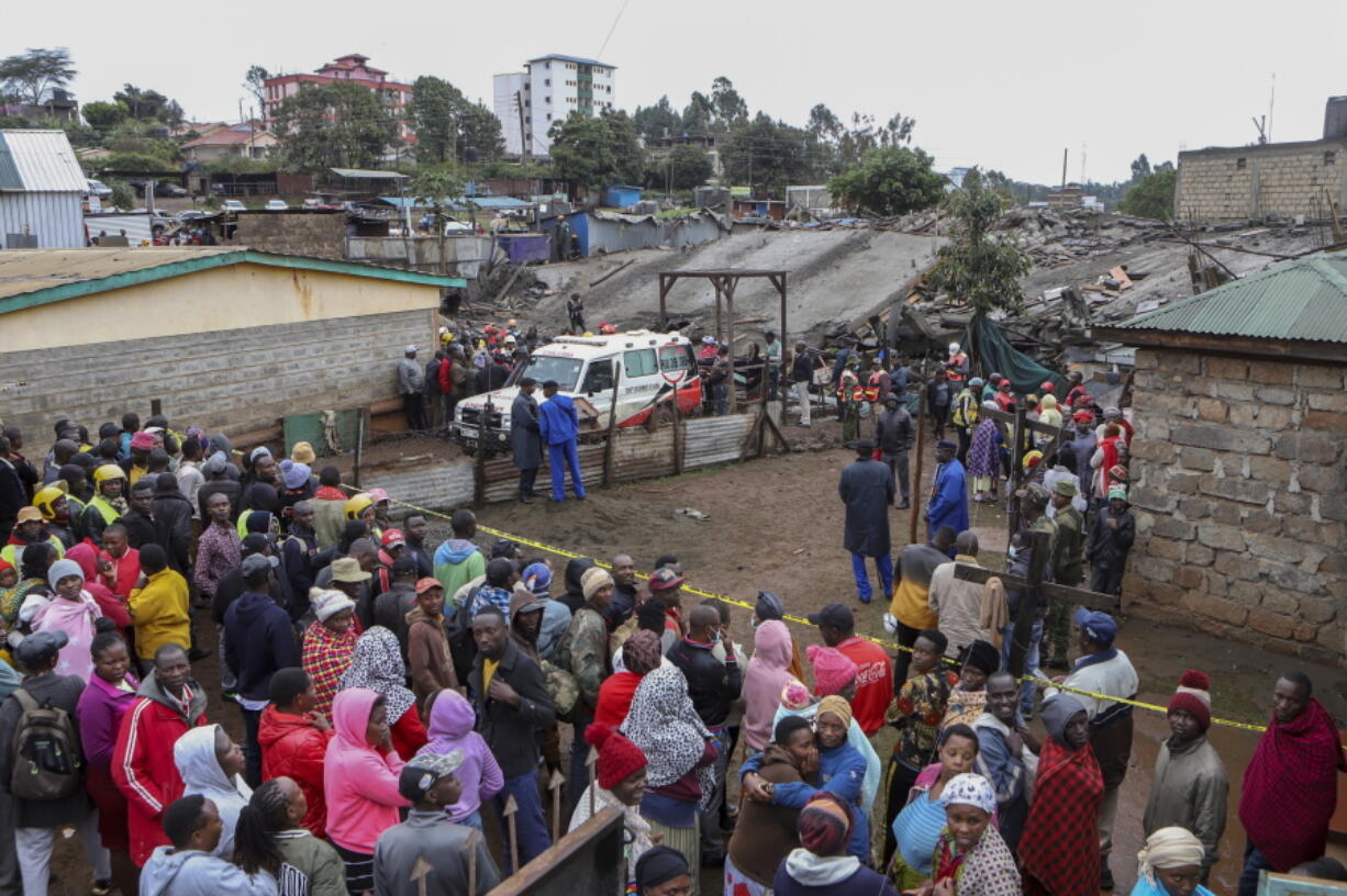 Onlookers gather at the scene of a building collapse in Ruaka, on the outskirts of the capital Nairobi, Kenya Thursday, Nov. 17, 2022. The collapse of the building under construction is the second such collapse in a matter of days in Nairobi, where housing is in high demand and unscrupulous developers often bypass regulations.