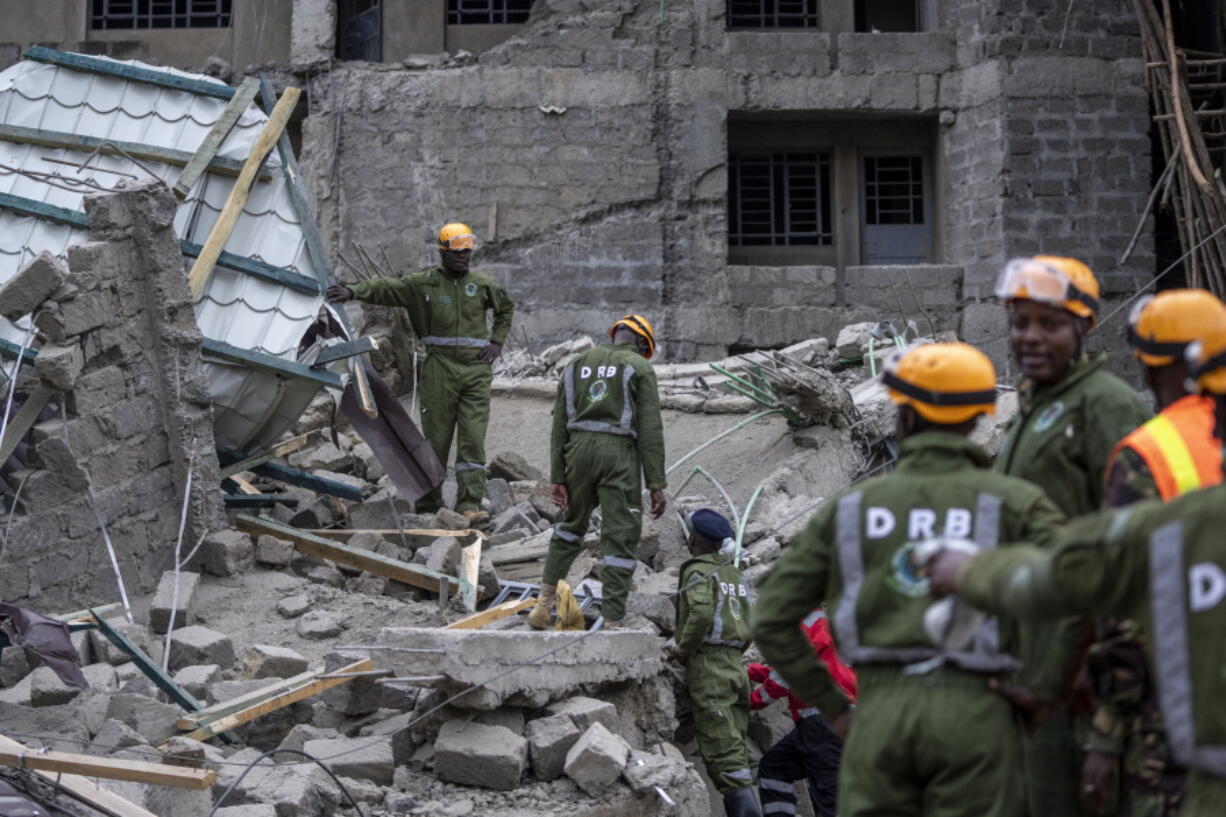 Personnel from the Kenya Defence Forces disaster response unit examine the scene of a building collapse in the Kasarani neighborhood of Nairobi, Kenya Tuesday, Nov. 15, 2022. Workers at the multi-storey residential building that was under construction are feared trapped in the rubble and rescue operations have begun, but there was no immediate official word on any casualties.