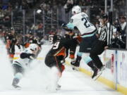 Seattle Kraken's Vince Dunn (29) leaps to avoid a check from Anaheim Ducks' Sam Carrick (39) during the first period of an NHL hockey game Sunday, Nov. 27, 2022, in Anaheim, Calif. (AP Photo/Jae C.